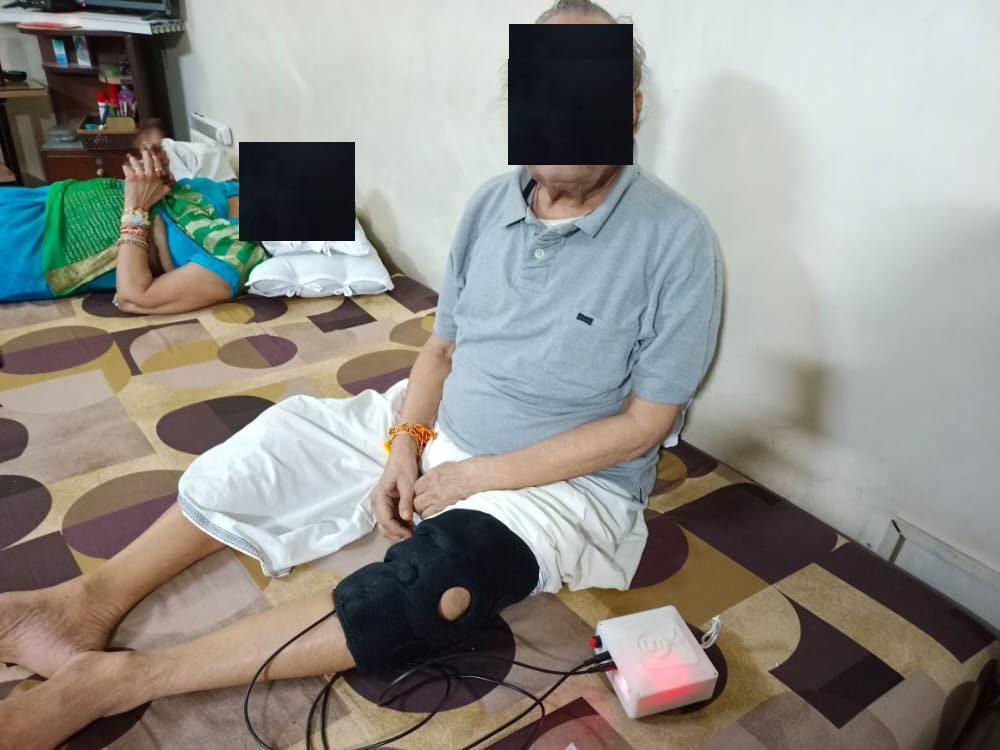 A person resting at home while wearing the SwaKnee applicator on the knee (identity obscured)