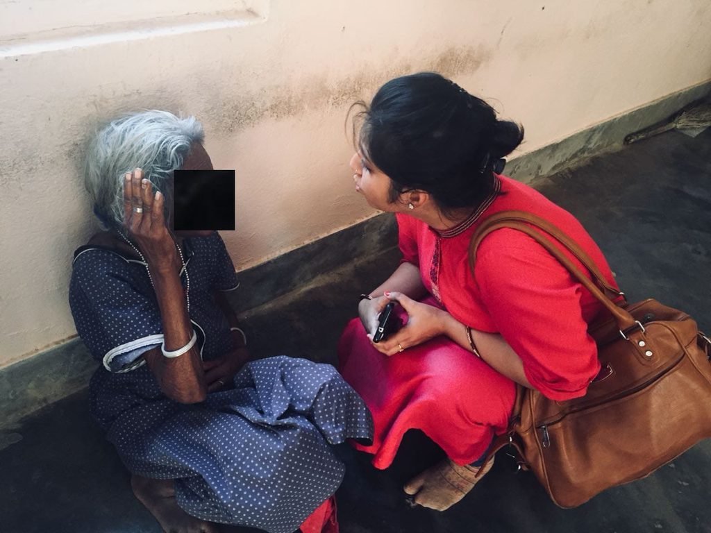 A Swayogya team member talking with an elderly patient during a home visit